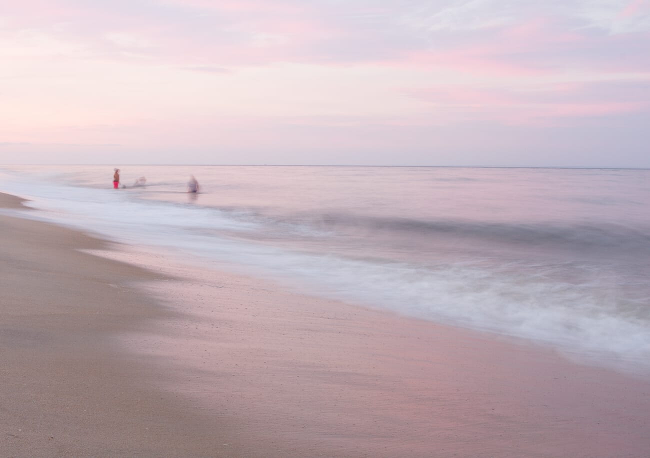 People walking on beach frozen with fast shutter speed