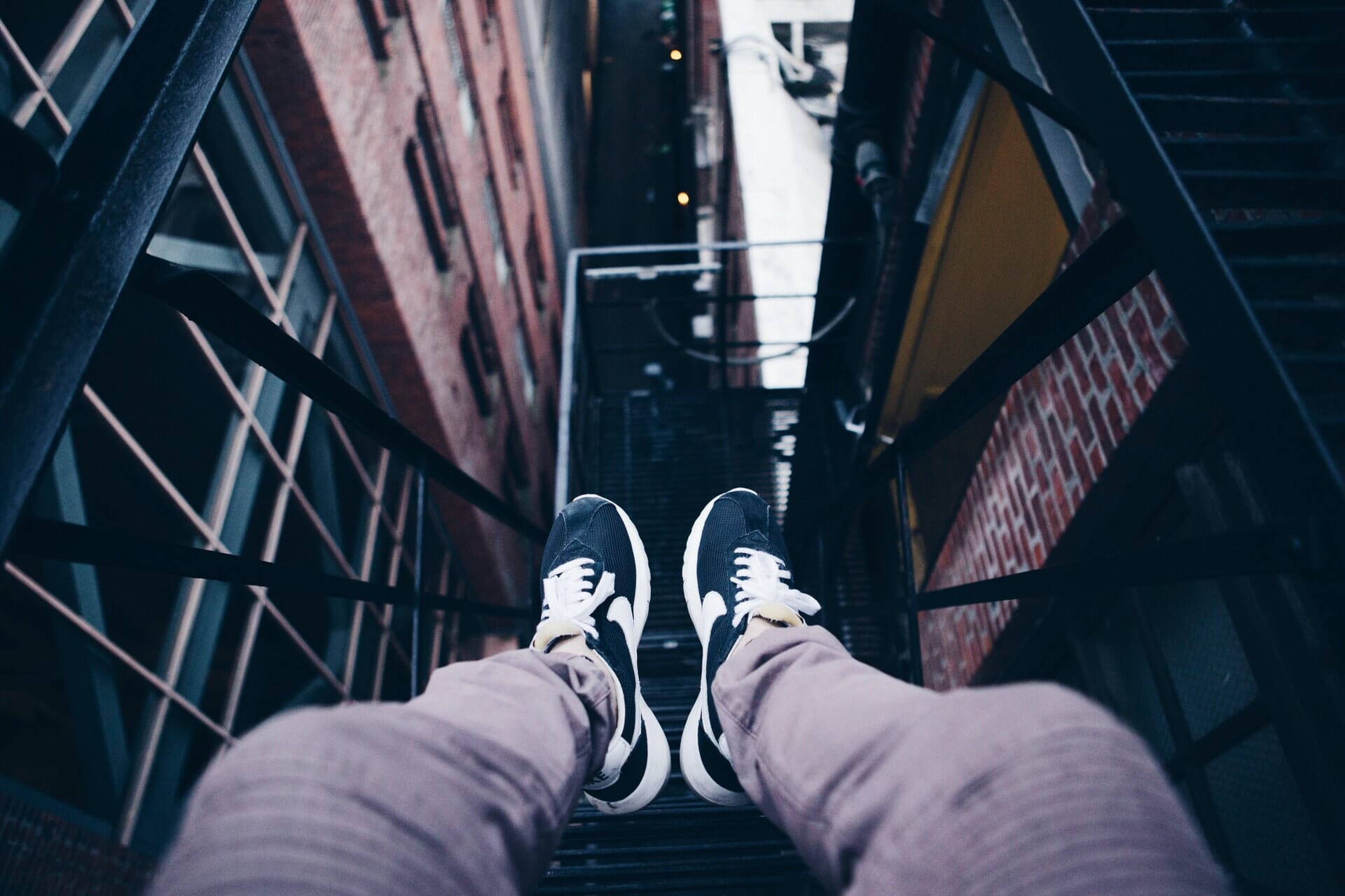 Feet dangling perspective from a fire escape