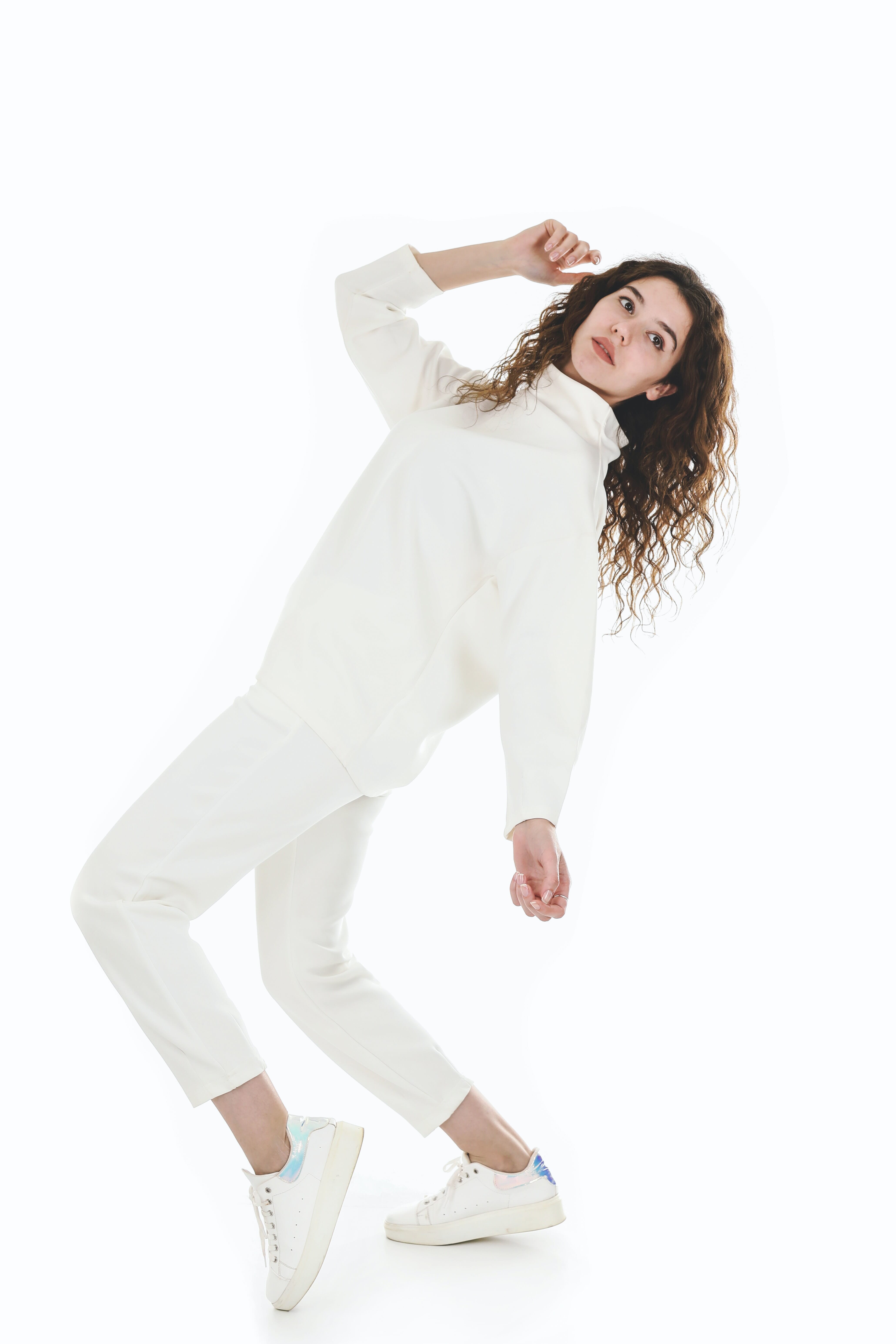 Capture stunning portraits with a pure white backdrop. A model in all-white attire poses dynamically, showcasing clean lines and an elegant aesthetic against a seamless white.