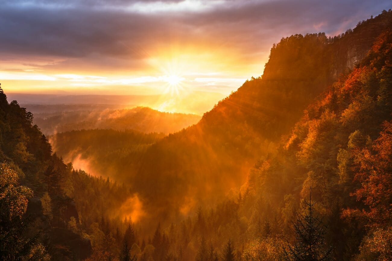 Sunrise over a misty valley with the sun rendered as a starburst at f/22