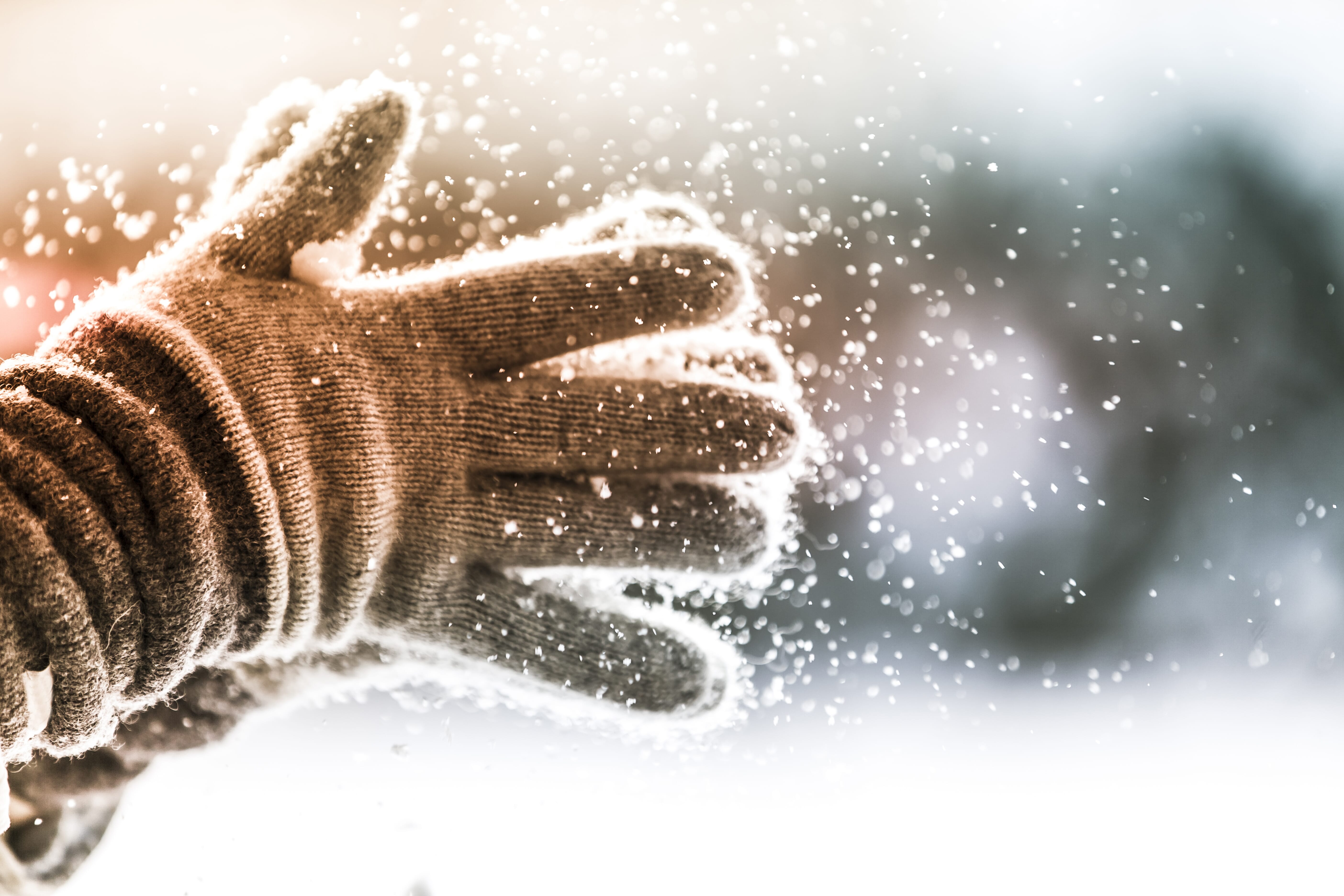 Close-up of gloved hands dusting off snow.
