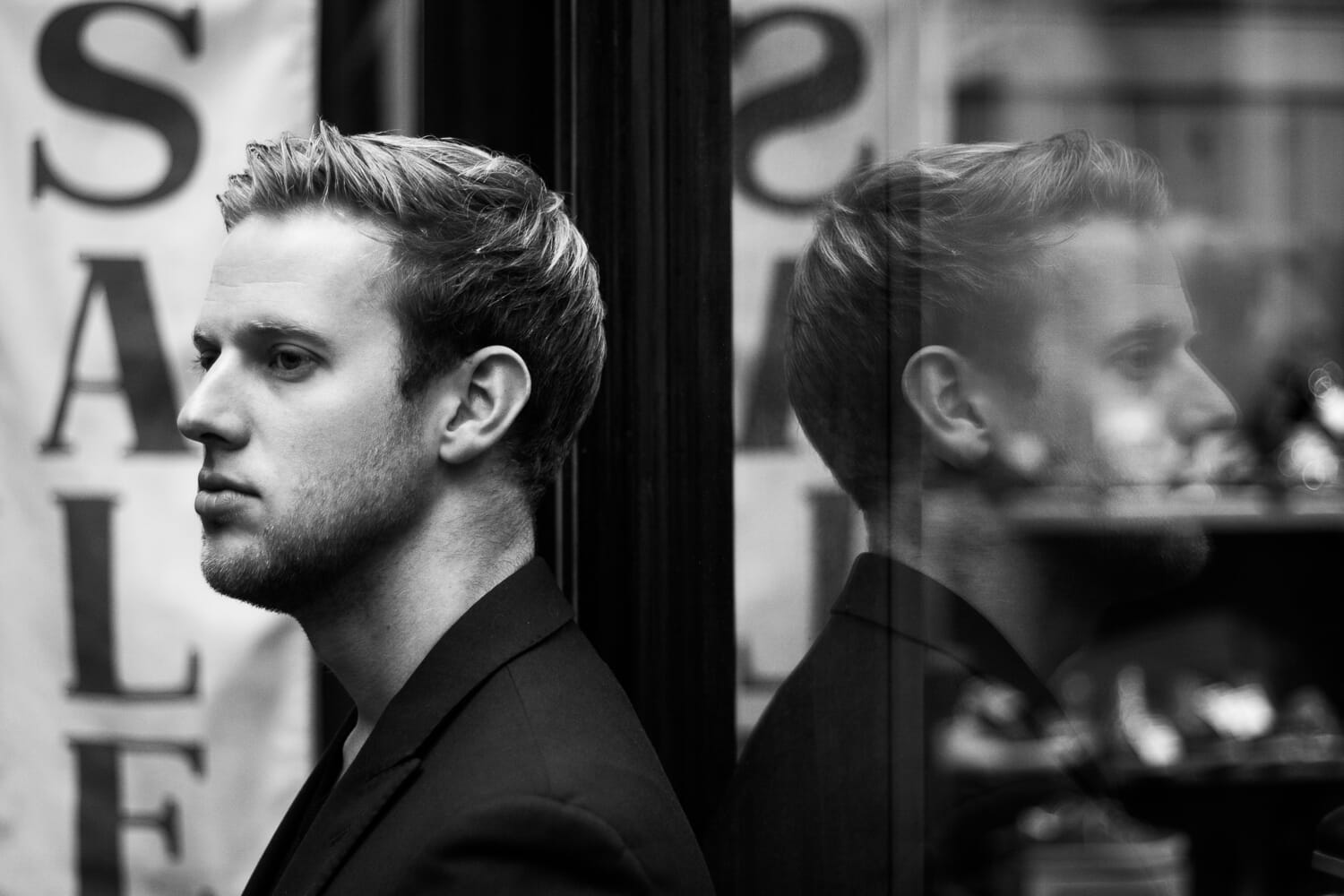 Portrait of man reflecting in window