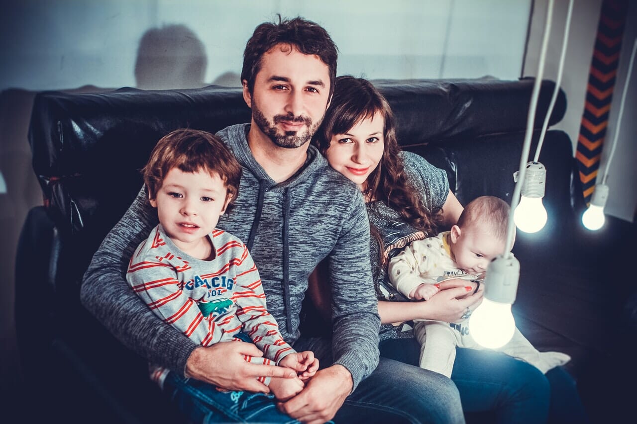 Family portrait of man, woman, and two children indoors
