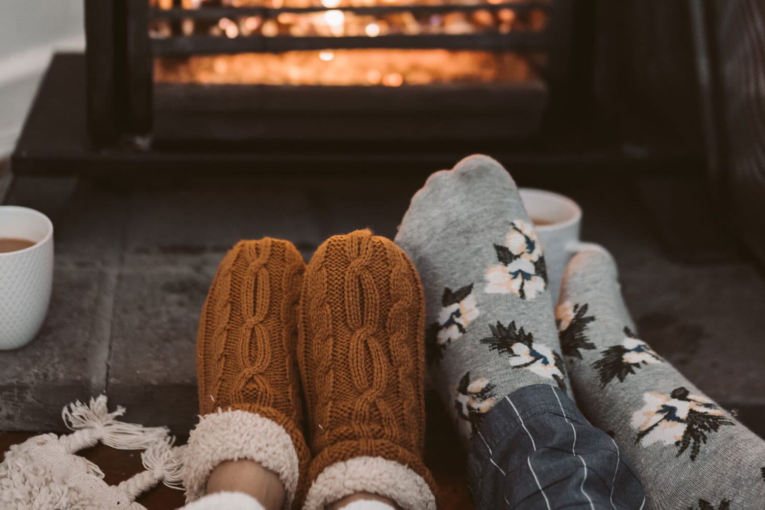 Couple with feet up in front of a fire