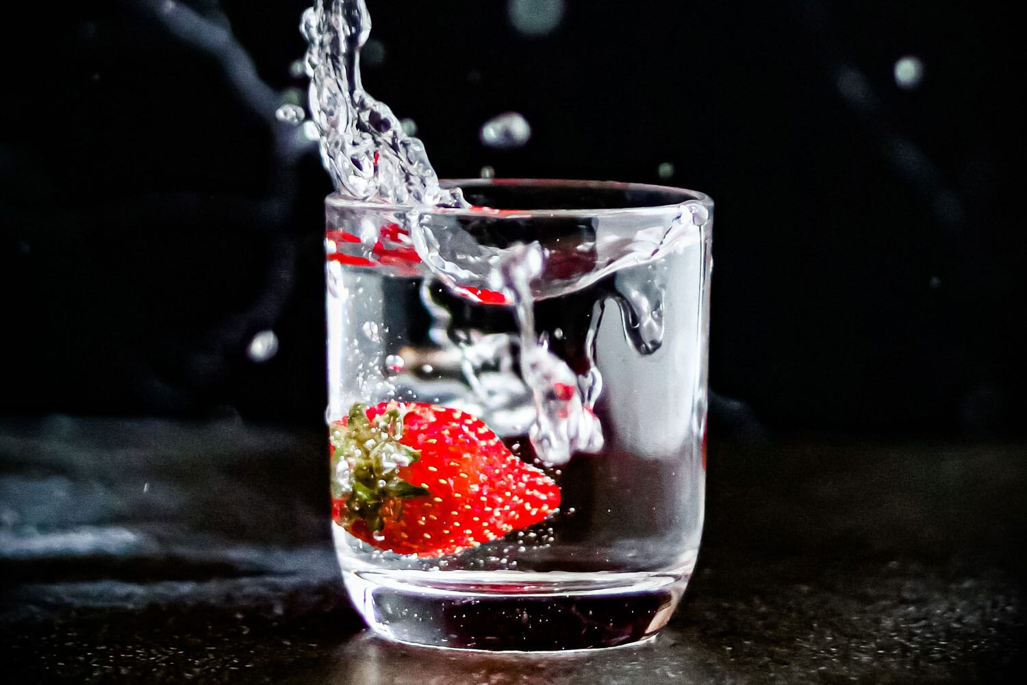 Strawberry dropped into water glass