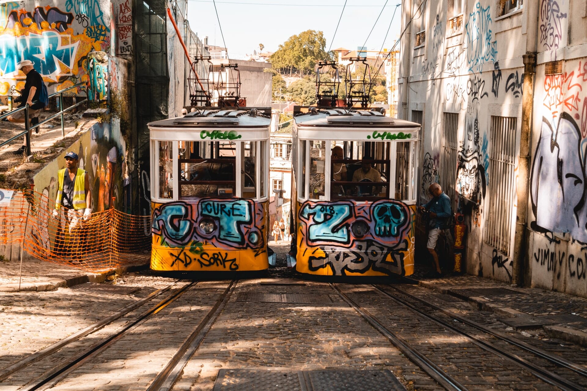 Graffiti covered trams in street scene.