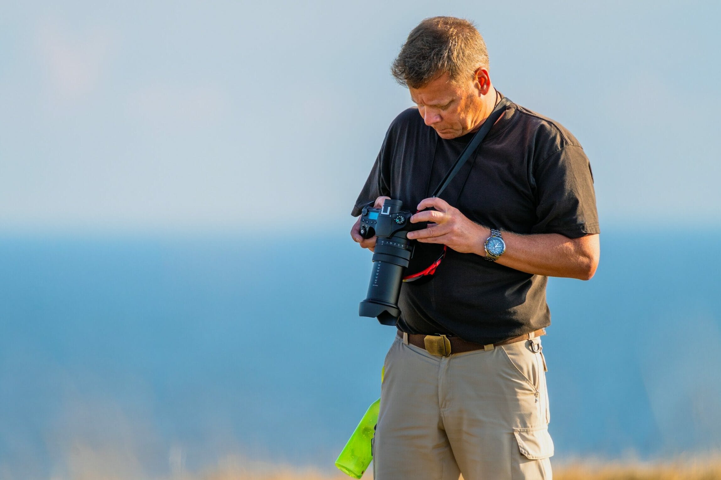 man looking at camera settings