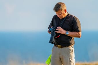 man looking at camera settings