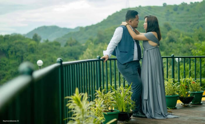 couple leaning close to each other with mountains as their background