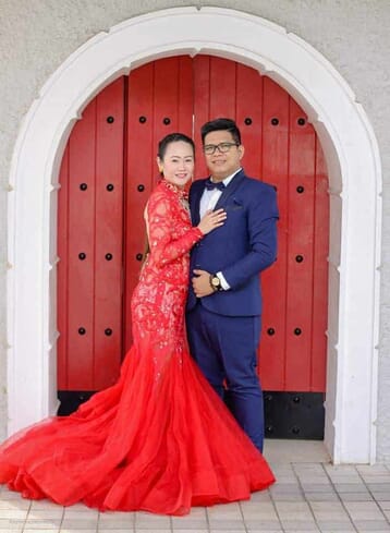 Full body picture of couple leaning to each other and facing the camera