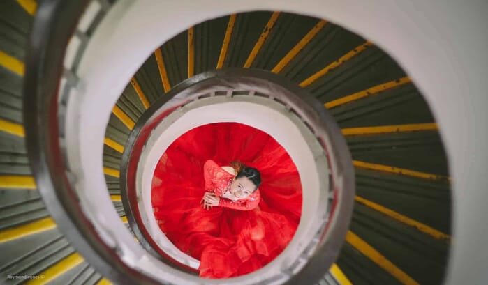 spiraling staircase with girl in gown in the middle