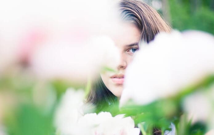 portrait with sharp eye showing through flowers