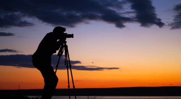 photographer with photography gear tripod setup