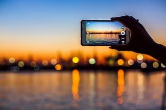 smartphone photographing sunset