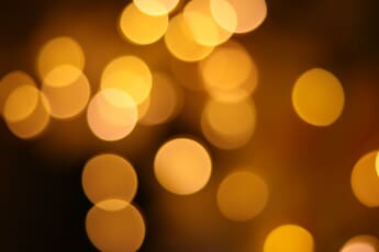 Capturing bokeh example of a cluster of yellow lights surrounded by darkness.