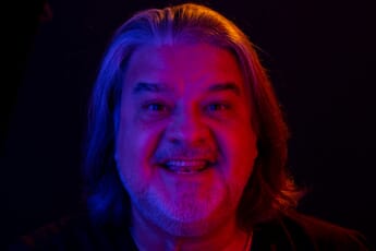 Closeup headshot of man with gel colored flashlights.