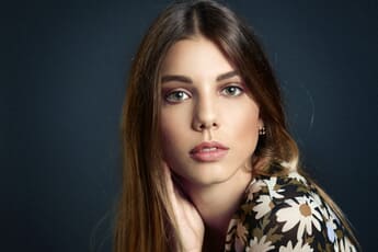 Portrait of a young woman, flash photography, dark background.