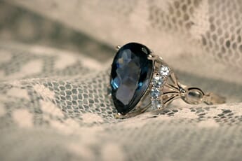 Close-up of a gem ring set on lace.