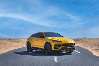A yellow lambo on a desert road in Dubai.