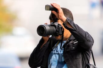 Man shooting with a Nikon camera and a flashgun