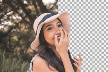 Woman with a large hat smiling against a split background with a Photoshop checkered pattern.