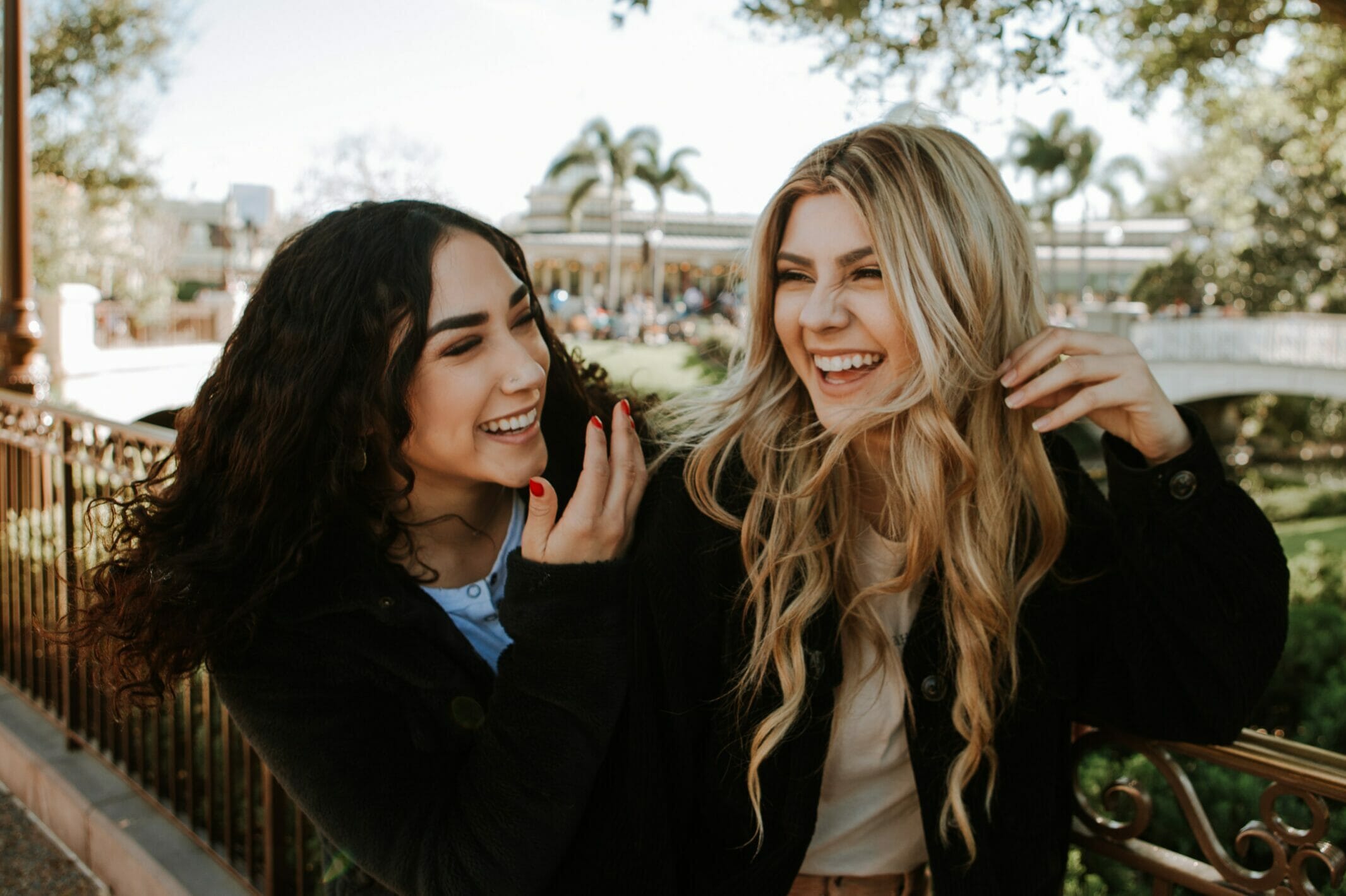 Two female friends laughing outdoors.