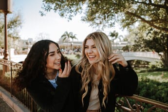 Two female friends laughing outdoors.