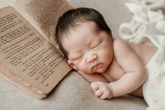 Baby sleeping with a book photo prop.