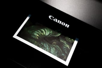 Black Canon inkjet printer currently printing an image of a green plant