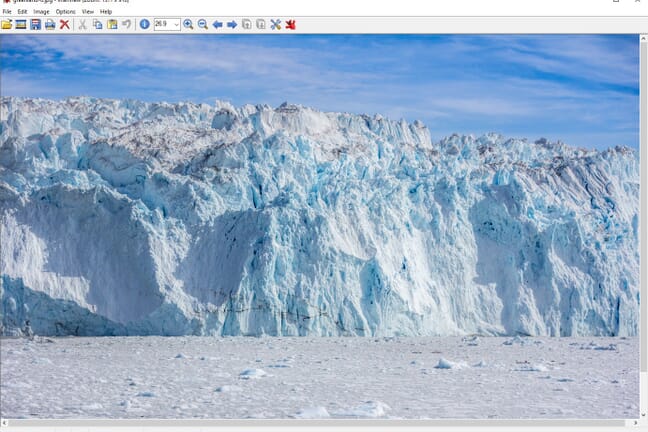 The editing interface in IrfanView with tool icons along the top and an image of an ocean and a glacier with blue sky in the background.