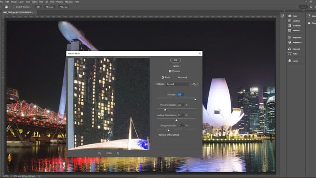 The Reduce Noise dialog box open over the Photoshop main window with an urban nightscape photo.