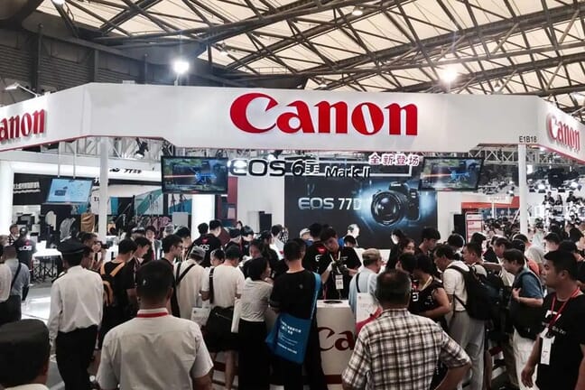 People standing around the Canon Booth at the Photo & Imaging Shanghai exhibition.