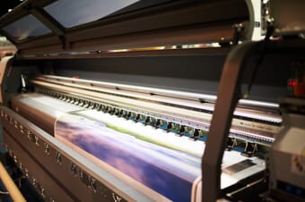 Close-up of wide-format printer interior printing a landscape photo.
