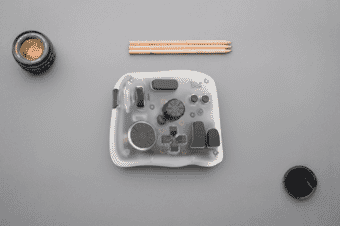 Controller for photo and video shown with a camera lens and pencils.