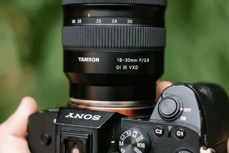 Close-up of a Tamron 18-30mm F/2.8 Di III VXD camera lens mounted on a Sony mirrorless camera, showcasing premium build and precision design.