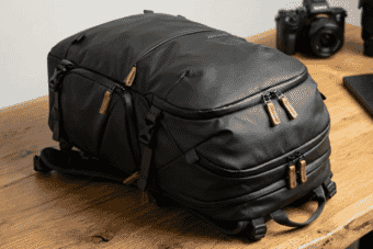 Sleek black camera backpack with multiple compartments and leather zipper pulls, designed for photographers and gear storage on professional shoots.