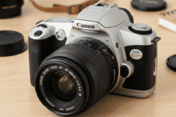 Close-up of a vintage Canon EOS Kiss film camera with a Canon Zoom Lens EF 35-80mm, displayed on a wooden surface with lens caps nearby.