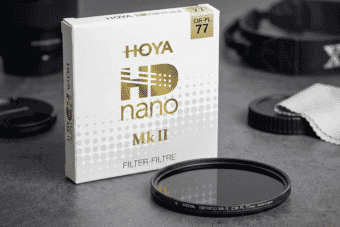 The HOYA HD Nano Mk II 77mm circular polarizer filter is displayed beside its sleek packaging, ideal for professional lens protection and glare reduction.