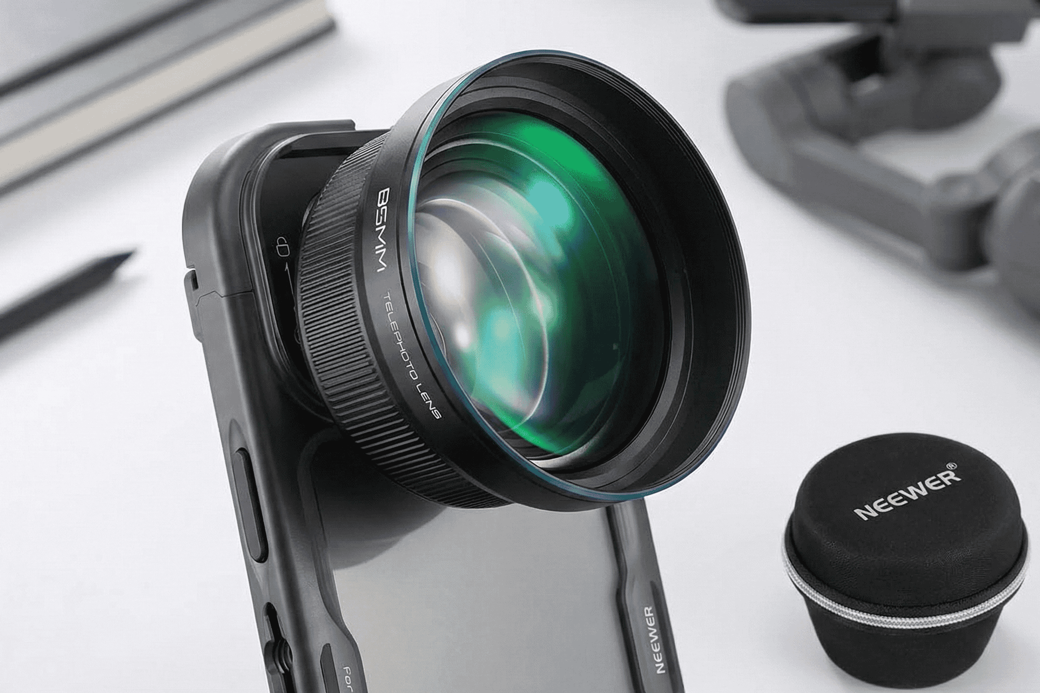 Close-up of a high-quality Neewer 85mm telephoto lens attached to a smartphone, showcasing sharp optics and a sleek professional design.