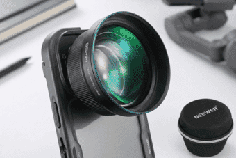 Close-up of a high-quality Neewer 85mm telephoto lens attached to a smartphone, showcasing sharp optics and a sleek professional design.