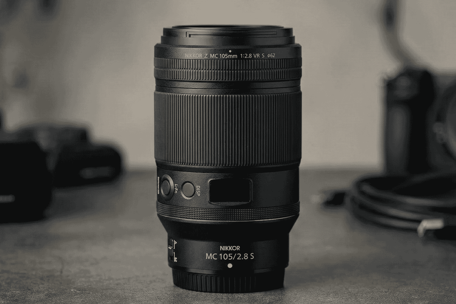 Close-up of the NIKKOR Z MC 105mm f/2.8 S VR macro lens with a sleek black design, ideal for detailed macro photography and portraits.