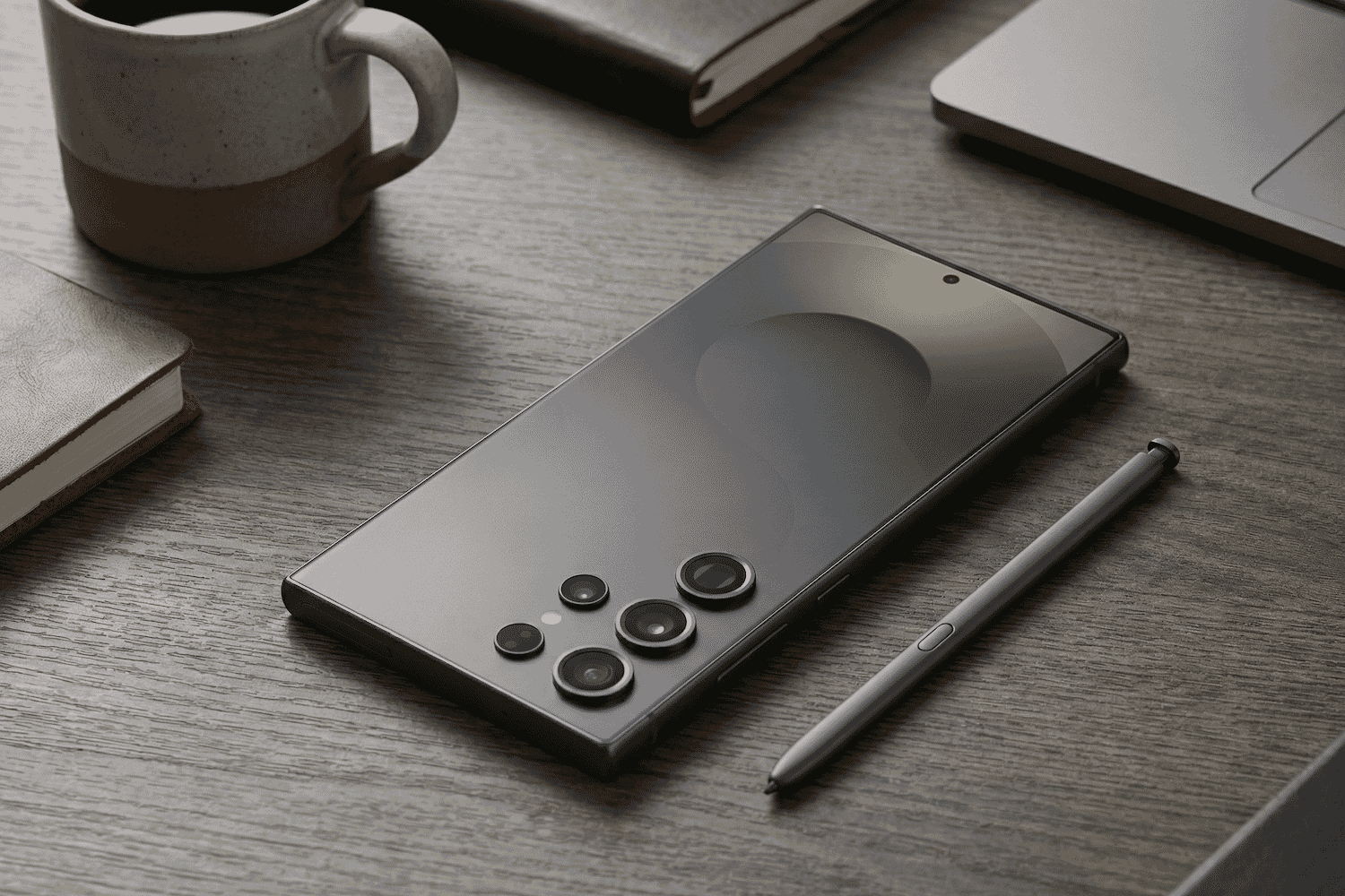 A sleek Samsung Galaxy S smartphone and stylus rest on a modern wooden desk, surrounded by tech accessories and minimalist workspace decor.