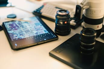 Photography editing setup with camera, laptop, and editing tablet on a well-lit desk - essential tools for managing and backing up Lightroom photos