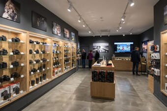 Modern camera store interior with display cases showing professional cameras and lenses