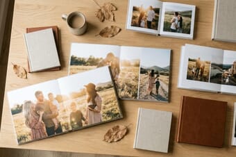 Premium photo books displayed on a wooden table showing family photos and travel memories
