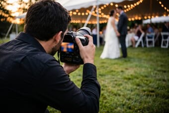 Event photographer capturing first dance at outdoor wedding reception