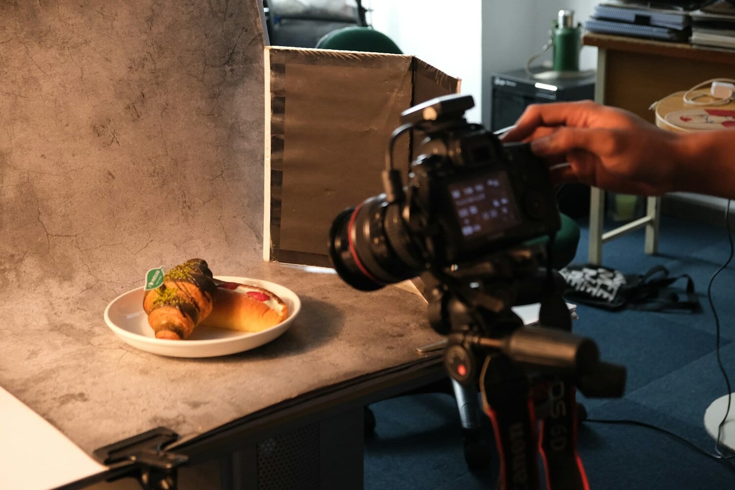 Food photography setup with camera on tripod photographing plated food with natural light