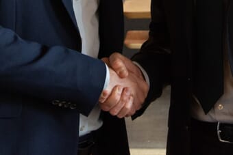 Business partners shaking hands representing the Getty Images and Shutterstock merger deal