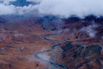 A winding mountain road cutting diagonally through misty peaks, demonstrating golden triangle composition