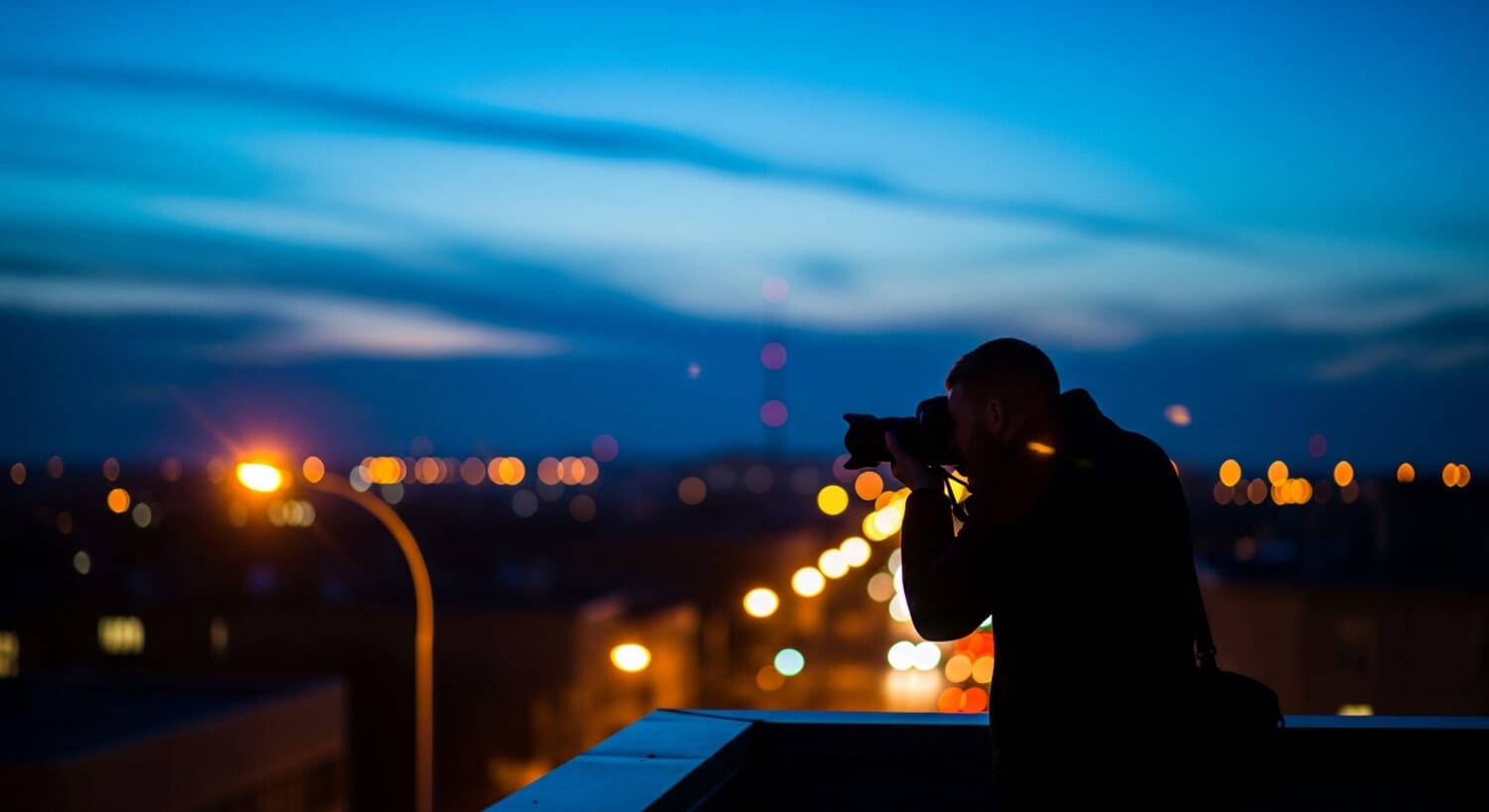 Photographer shooting in low light conditions during blue hour in a city